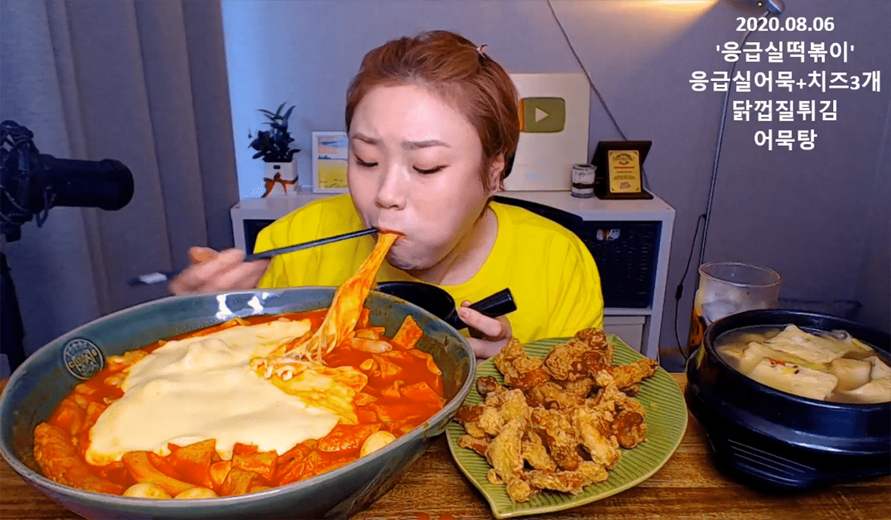 吃播主在直播中展示一大碗韓國辣炒年糕和炸雞，其代表性食物。